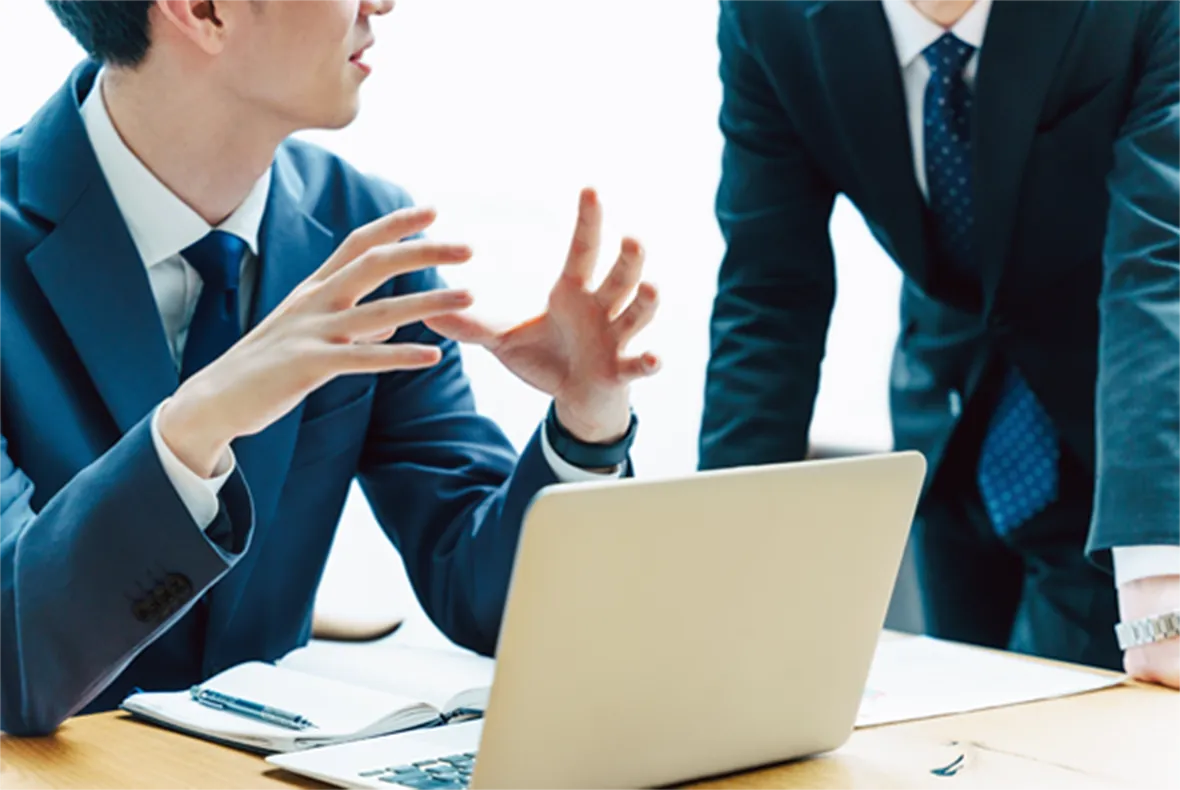 パソコンを前にビジネスの会話をする様子
