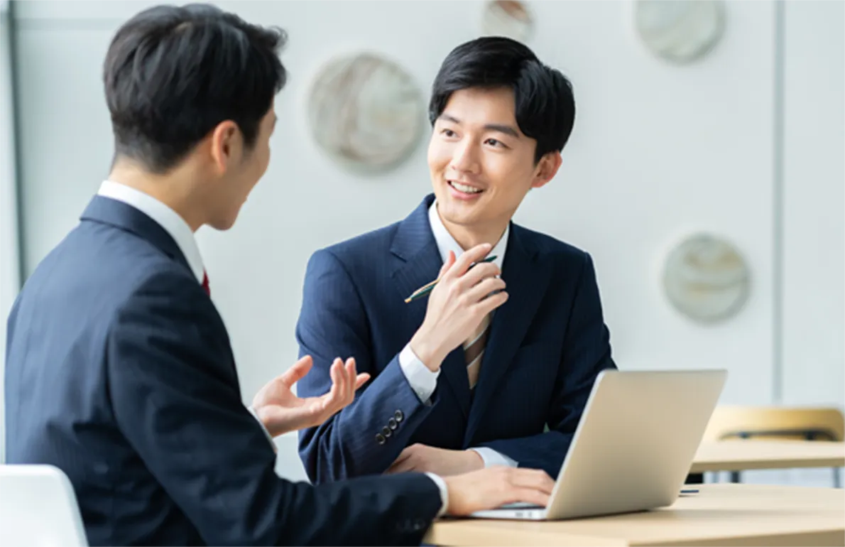 パソコンを前にビジネスの会話をする様子